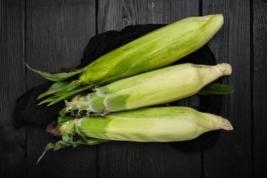 Mısırın kulağı ya da mısır seti, siyah taş masa arkaplanı üzerinde, üst görünüm düz yatıyordu