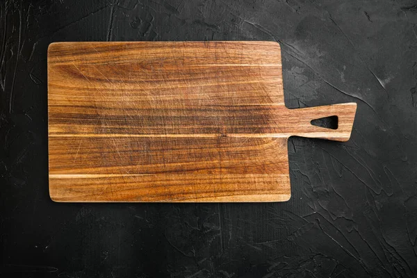 Metin ya da yiyecek kopyalamak için boş bambu kesme tahtası kullanılıyor, üst görünüm düz, siyah koyu taş masa arkaplanı üzerinde