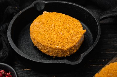 Pişmemiş balık köfteleri, siyah ahşap masa arkasında.