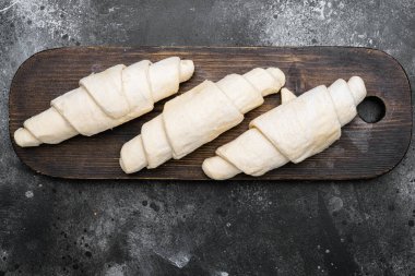 Donmuş çiğ kruvasan seti, siyah taş masa zemininde, üst manzara düz yatıyordu.