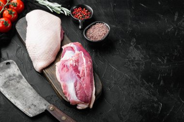 Çiğ ördek göğsü, eski kasap bıçağı ile, siyah taş arka planda, metin için telif alanı ve boşluk ile