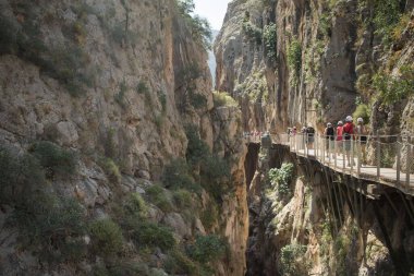 Güneşli bir günde Caminito del Ray 'de yürüyen turistler
