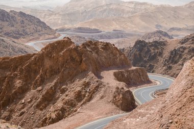 Dağlar arasında sonsuz dar bir yol. Hiçliğin ortasında ıssız, küçük, boş bir yol. Ortadoğu doğası. Ürdün çölünün ortasında manzaralı bir yol..