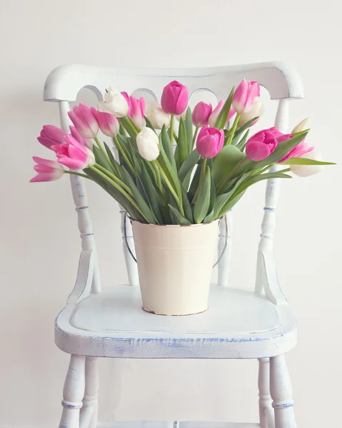 Tulipanes brillantes en silla — Foto de Stock