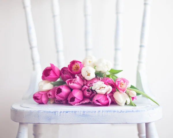 Яркие тюльпаны на стуле — стоковое фото