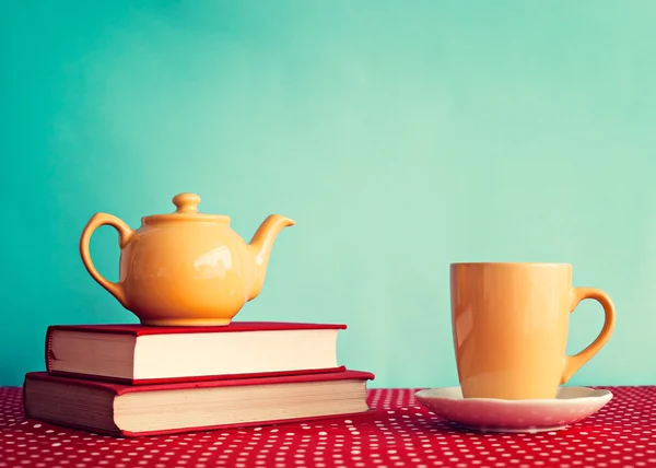 Yellow teapot over books — Stock Photo, Image