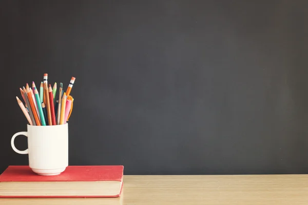 Pencils and book on table — Stock Photo, Image