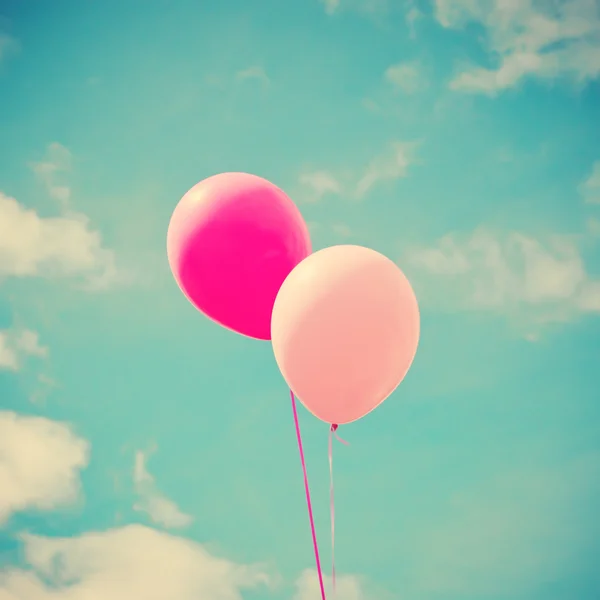 Colorful balloons over vintage sky