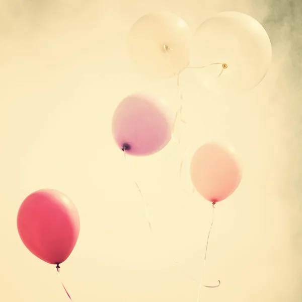 Colorful balloons over vintage sky