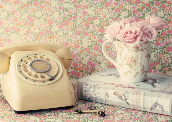 Rétro Téléphone et roses en tasse sur le livre — Photo