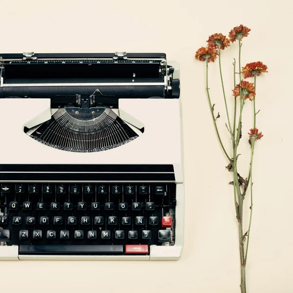 Typewriter and flowers on table — Stock Photo, Image