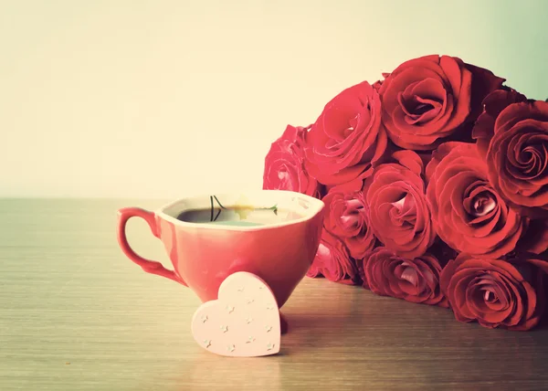 Rote Rosen und eine Tasse Kaffee — Stockfoto