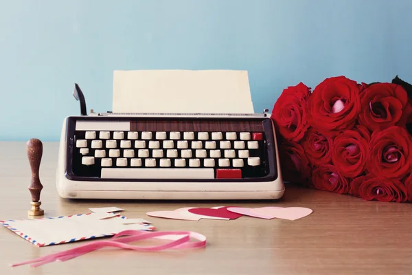 Vintage typewriter and bouquet of roses — Stock Photo, Image