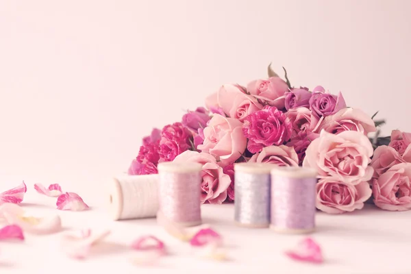 Peonies and roses and spools of thread — Stock Photo, Image