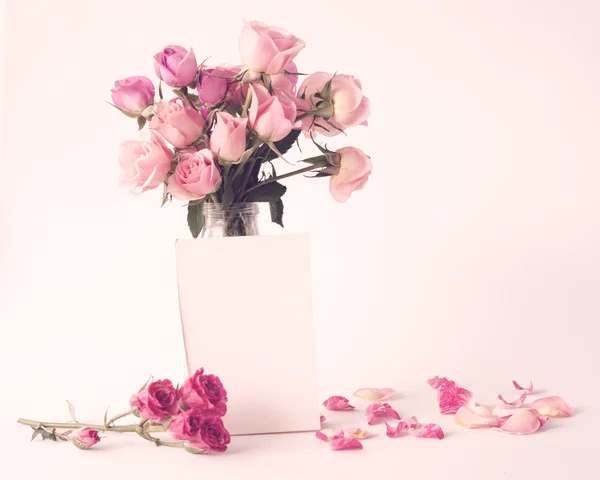 Rosas rosadas en jarrón con tarjeta blanca — Foto de Stock