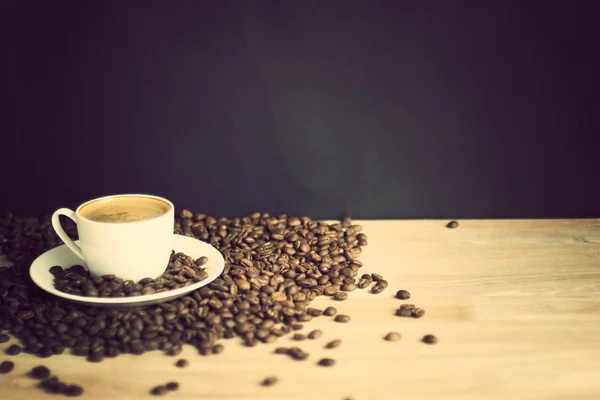 Tasse à café et haricots sur bois — Photo