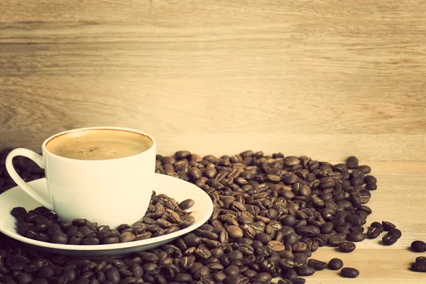 Coffee cup and beans over wood — Stock Photo, Image