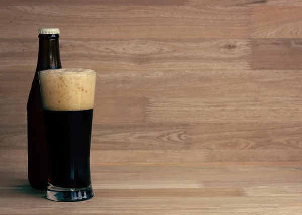 Пиво стекло и бутылка на дереве — стоковое фото