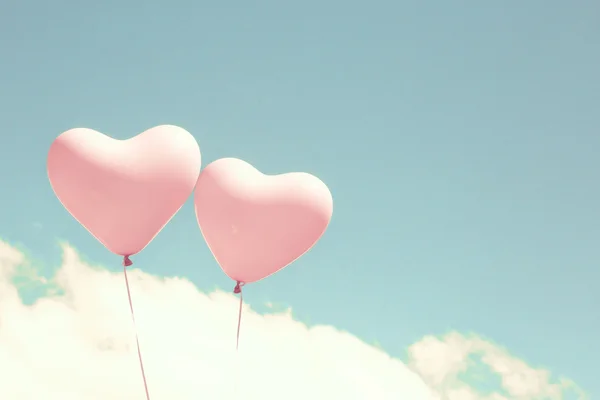 Retro pink heart shaped balloons in flight