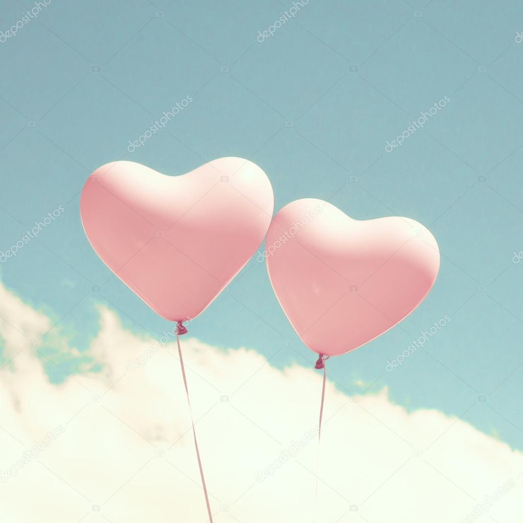 Retro pink heart shaped balloons in flight