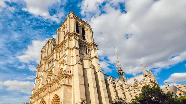 Notre Dame de Paris on background of blue cloudy sky in Paris in summer.