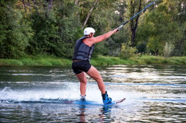 Yaz günü can yeleğiyle gölde uyanan bir adam. Yumuşak odaklanma. Eylem bulanıklığı. 