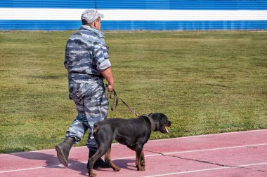 Abakan, Rusya - 21 Ağustos 2018: Koyun köpeğiyle devriye gezen kamuflajlı bir asker.