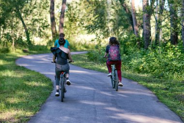 Bir grup arkadaş yazın bir parkta bisiklete biniyorlar..