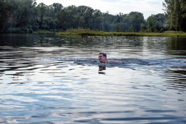 Yazın nehirde yüzen bir adam.