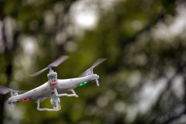 Yerden kalkan beyaz bir dron kuadkopteri. Yumuşak odaklanma. Hareket bulanıklığı.