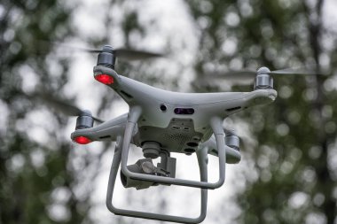 Yerden kalkan beyaz bir dron kuadkopteri. Yumuşak odaklanma. Hareket bulanıklığı.