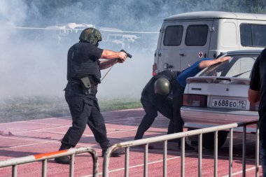 Yangın dumanı ve patlamayla suçluyu tutuklayan bir SWAT ekibi var. Aksiyon bulanıklığı: Abakan, Rusya - 21 Ağustos 2018