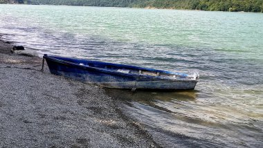 Yazın nehrin kıyısında eski ahşap bir tekne..