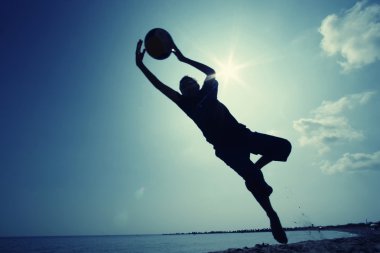 Kumsalda futbol oynayan çocuk