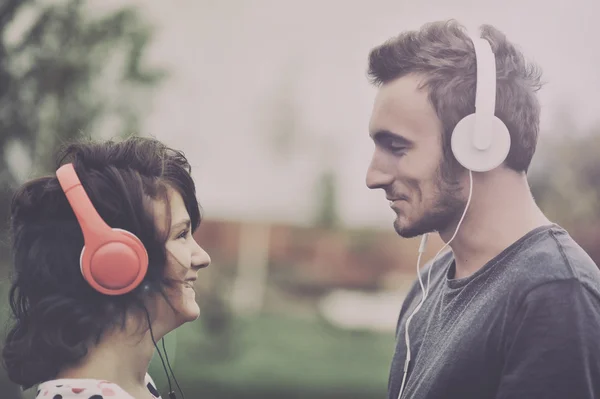 Casal ouvindo música em fones de ouvido — Fotografia de Stock