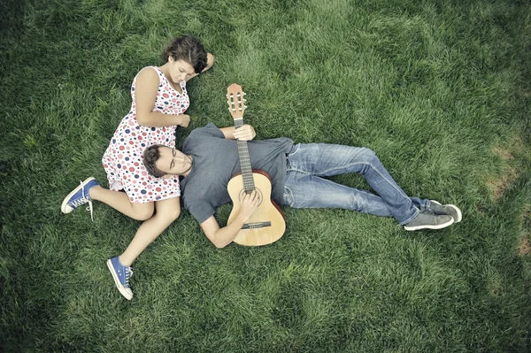 Pojke spela gitarr för en flicka — Stockfoto