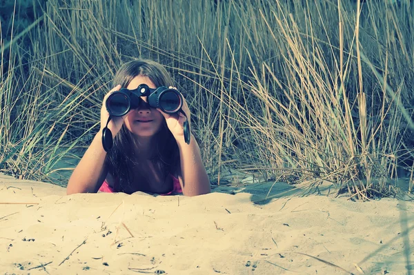 Ung flicka tittar genom kikare — Stockfoto