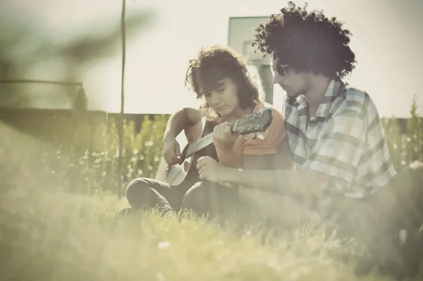 Boy teaches girl to play guitar — Stock Photo, Image