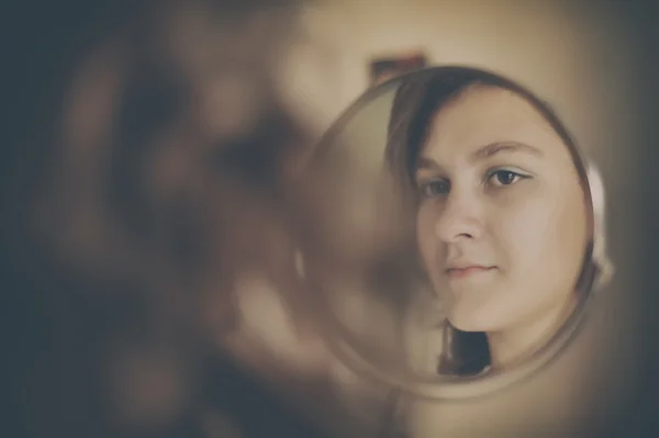 Girl looking in mirror — Stock Photo, Image