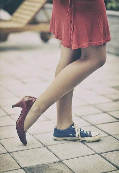 Woman legs in different shoes — Stock Photo, Image