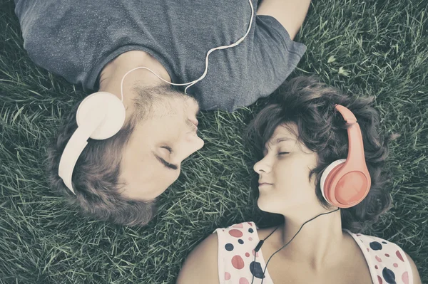 Couple listening to music on headphones — Stock Photo, Image