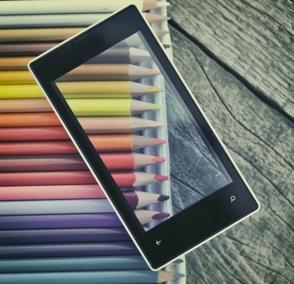 Mobile phone on colorful pencils — Stock Photo, Image