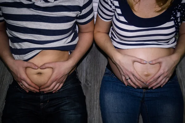 Jovem grávida casal mostrando grande estômago — Fotografia de Stock