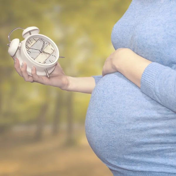 임신한 여자는 시계에서 보이는 — 스톡 사진