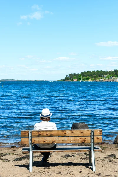 밀 짚 모자 벤치에 혼자 앉아 있는 젊은 여자 — 스톡 사진