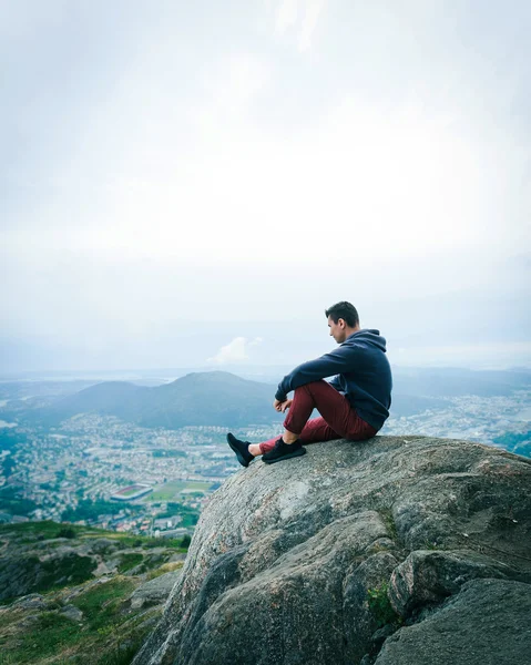 Un type assis sur un rocher dans les montagnes — Photo
