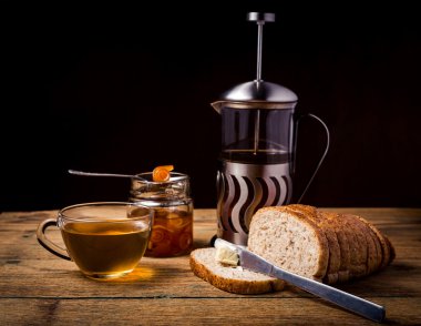 Çay ve ekmek ile ahşap zemin üzerine portakal marmelat