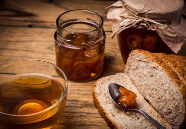 Çay ve ekmek ile ahşap zemin üzerine portakal marmelat