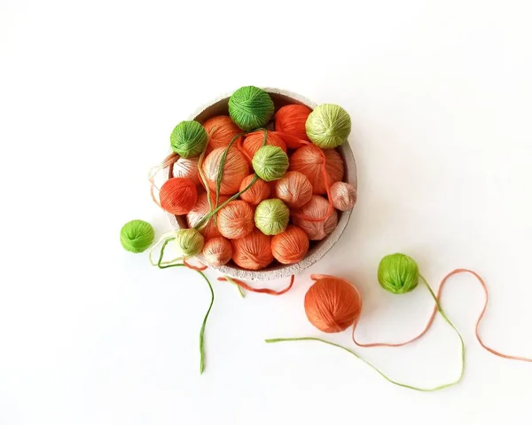 Оранжевые и зеленые шарики пряжи для ручного вязания. — стоковое фото