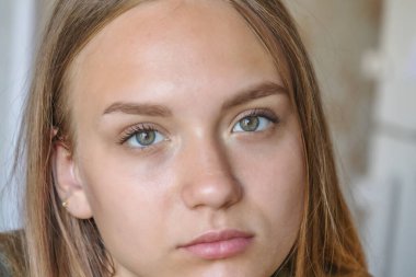 Uzun saçlı ve büyük gözlü güzel bir genç kızın portresi.